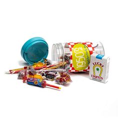 an assortment of candies and candy on a white surface with a blue container next to it