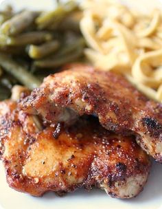 two pieces of chicken, green beans and pasta on a plate