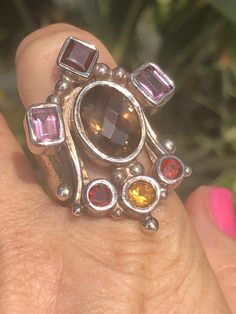 Amazing unique big gemstone ring smoky quartz, amethyst, Garnet and citrine. Ring sterling silver 925 Queen/ Royal Statement Size 10. Amazing ring. Extremely unique, I've never seen one like it. It truly feels like a medieval piece of jewelry that a queen or king would wear. Unusual and abstract piece. Would be perfect for a statement piece or even a Renaissance fair. The ring is well-made and solid. Signed 925. Smoky Quartz Gemstone Ring Jewelry, Smoky Quartz Gemstone Ring, Unique Multi-stone Amethyst Ring In Sterling Silver, Unique Multi-stone Amethyst Ring For Anniversary, Elegant Sterling Silver Amethyst Ring, Unique Amethyst Ring With Accent Stones, Unique Multi-stone Topaz Jewelry, Unique Multi-stone Amethyst Ring For Gift, Unique Citrine Gemstone Crystal Ring