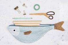 a fish shaped object with scissors and other items