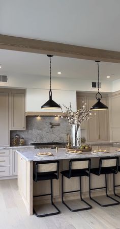 a large kitchen with an island in the middle and four chairs at the counter top