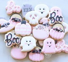 cookies decorated with pink and white icing are arranged in the shape of boos