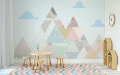 a child's room with colorful mountains painted on the wall and two wooden stools