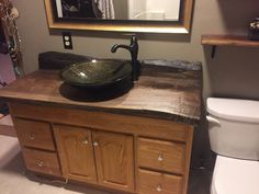 a bathroom with a sink, toilet and mirror on the wall in front of it