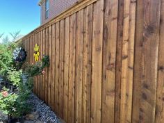 a wooden fence next to a flower garden