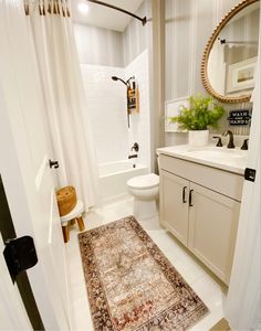 a bathroom with a rug, sink and toilet in it's centerpieces