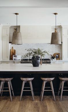 a kitchen with three stools and an island in front of the counter top is shown