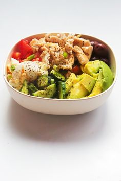 a white bowl filled with lots of different types of food on top of a table