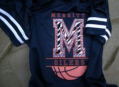 there is a shirt with the letter m on it and a basketball in the middle