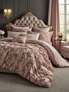 a bed with pink comforters and pillows in a room