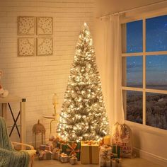 a christmas tree is lit up in front of a window