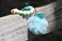 a tasseled keychain with beads and a pom - pom