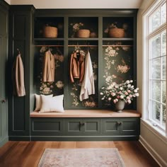 a room filled with lots of green cupboards and coats hanging on it's walls