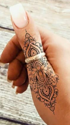 a woman's hand with a henna tattoo on it