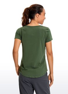 a woman is standing with her back to the camera and wearing a green t - shirt