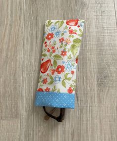 a pair of glasses sitting on top of a wooden floor next to a flowered cloth