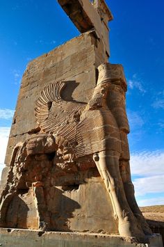 an ancient statue in front of a blue sky