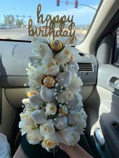 a car decorated with white flowers and gold glitters for a happy birthday card in the passenger seat