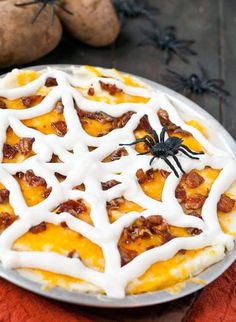 a pie with white icing on it and a spider sitting on top of it