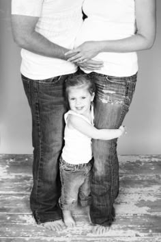 a black and white photo of a woman holding her daughter's belly while standing next to her