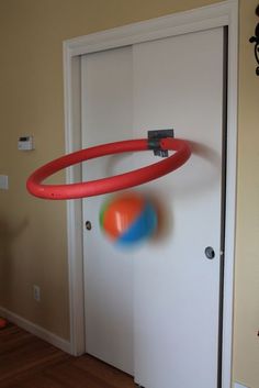 an orange and blue frisbee is in front of a door with a red ring on it