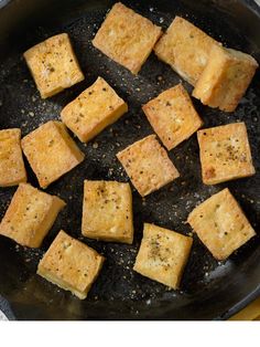 tofu cubes are being cooked in a skillet