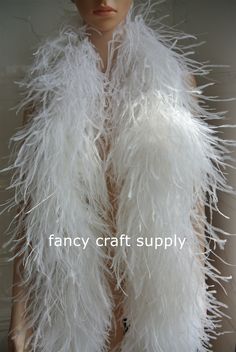 a mannequin is wearing a white feathered vest and headpiece with the words fancy craft supply on it