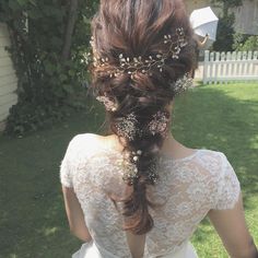 the back of a woman's head with flowers in her hair, wearing a wedding dress