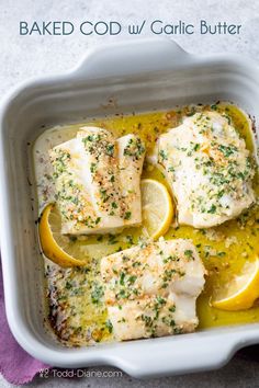 baked fish with garlic butter and lemon in a white casserole dish on a purple towel