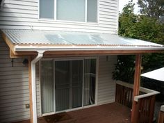 a white house with a wooden deck and an awning