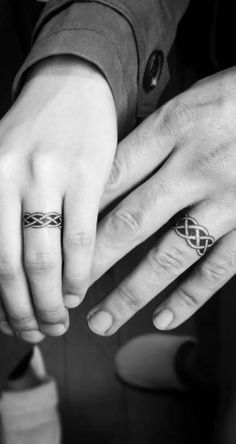 two people holding hands with rings on their fingers