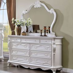 a white dresser and mirror in a room