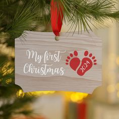 a wooden ornament hanging from a christmas tree that says, my first christmas day