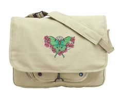 "Painterly details bring this floral Luna Moth to life. Luna Moth design embroidered on canvas messenger bag. Vintage Canvas Messenger Bag offers classic styling and functionality and features 3 inner compartments great for storage of books or gear, 1 outer compartment w/ snaps and a fully adjustable shoulder strap. Size: One Size 15\"W x 11\"H x 4\"D. Design size: 6.85\"(w) x 4.84\"(h) Strap is approx 40\" from end to end when fully extended Colors of thread in embroidery design, along with mat Embroidered Canvas Rectangular Shoulder Bag, Embroidered Cotton Shoulder Bag For Travel, Embroidered Canvas Shoulder Bag For Travel, Embroidered Beige Shoulder Bag For School, Beige Embroidered Shoulder Bag For School, Embroidered Cotton Shoulder Bag For School, Hogwarts Bag, Luna Moth Design, Slytherin Crest