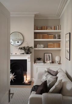 a living room filled with furniture and a fire place in front of a mirror on the wall