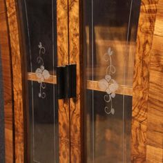 two wooden doors with floral designs on the glass and wood panels, one has a black handle