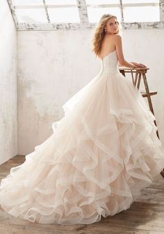 a woman in a wedding dress standing on a chair