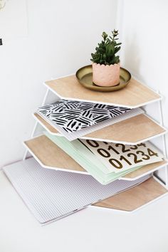 a stack of books sitting on top of each other next to a potted plant