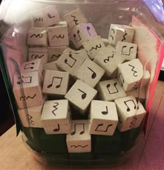 a glass container filled with wooden blocks and musical notes