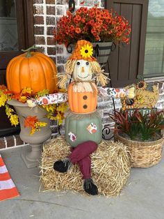 a scarecrow sitting on top of hay next to pumpkins and other fall decorations