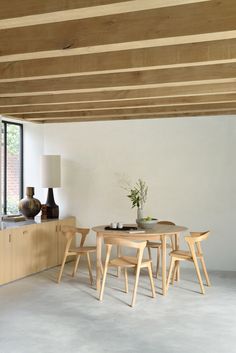 a table and chairs in a room with large windows