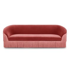 a red couch with fringe trims on the arms and back, against a white background