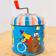 an old tin can with a bicycle painted on the side and a toothbrush sticking out of it