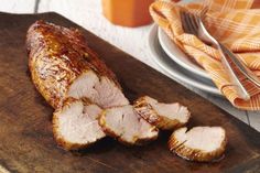 sliced pork on a cutting board with knife and fork