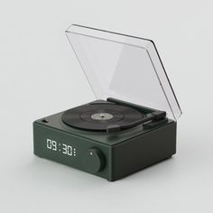 an alarm clock with a record player in it's display case on a white surface