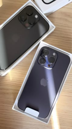 two new iphones in their packaging on a table