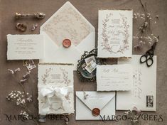 the wedding stationery is laid out on top of each other, including two envelopes