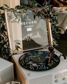 an old record player is decorated with greenery