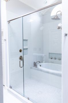 a white bathroom with a glass shower door