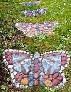 three stepping stones in the grass with a butterfly painted on them